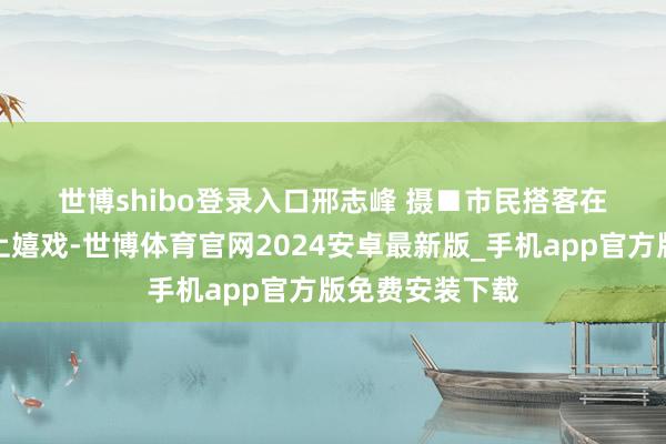 世博shibo登录入口　　邢志峰 摄　　■市民搭客在栈桥景区沙滩上嬉戏-世博体育官网2024安卓最新版_手机app官方版免费安装下载